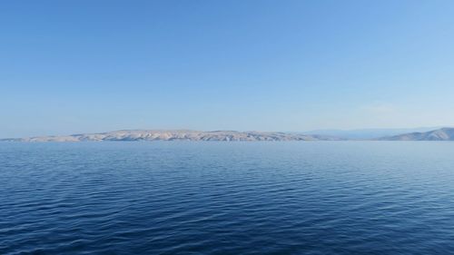 Scenic view of lake against clear blue sky