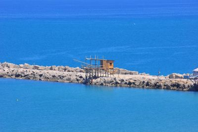 Blue sea and buildings against sky