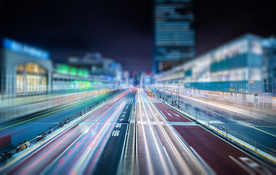 Tilt-shift image of road with buildings in city at night