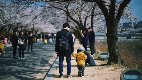 Rear view of people walking on footpath