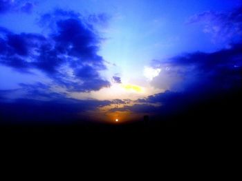 Silhouette of landscape against cloudy sky