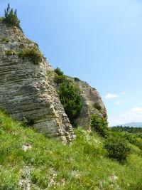 Low angle view of rocky mountain against sky