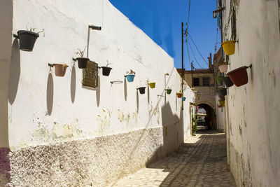 Footpath amidst buildings against sky