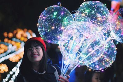 Portrait of smiling young woman illuminated decorations