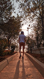 Rear view of man on footpath against sky