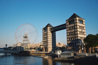 Ferris wheel in city against clear sky