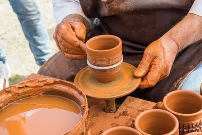 Midsection of man working on pottery wheel