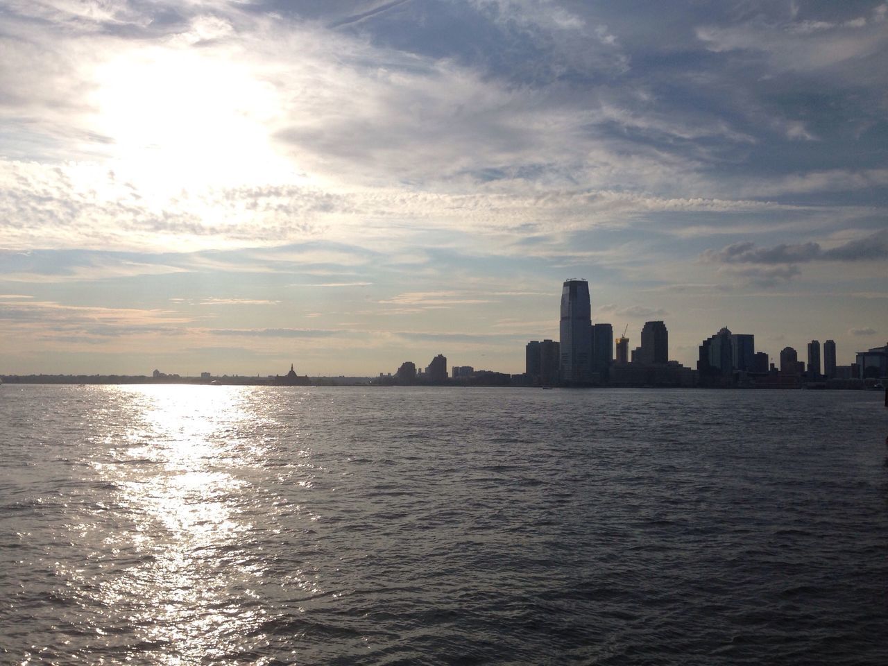 building exterior, city, architecture, water, waterfront, built structure, sky, cityscape, sea, skyscraper, urban skyline, sunset, cloud - sky, silhouette, river, skyline, tower, cloud, rippled, tall - high