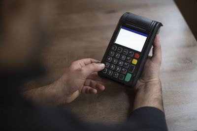 Man holding credit card reader at table