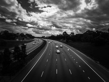 High angle view of vehicles on road against clouds