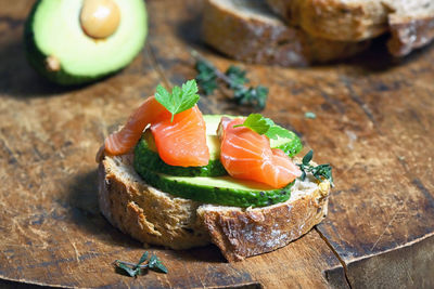 Bread with slices avocado. fresh salmon and spices