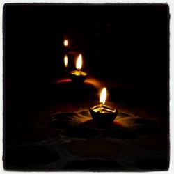 Close-up of lit candle in dark room