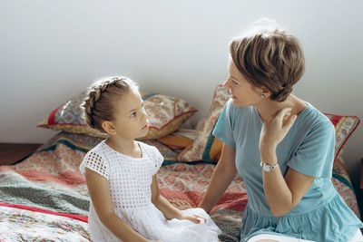 Mother looking at daughter hairstyle at home