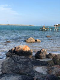 Rocks on beach against sky