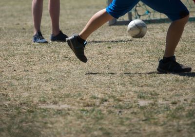 Low section of people playing soccer on land