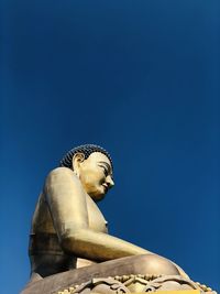 Low angle view of statue against blue sky