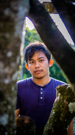 Portrait of young man standing in forest