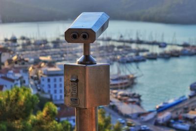 Close-up of coin-operated binoculars against river