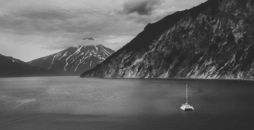 Scenic view of sea by mountains against sky