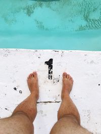 Low section of man standing at poolside