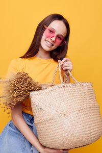 Portrait of smiling young woman holding basket