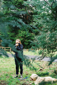 Full length of woman standing in forest