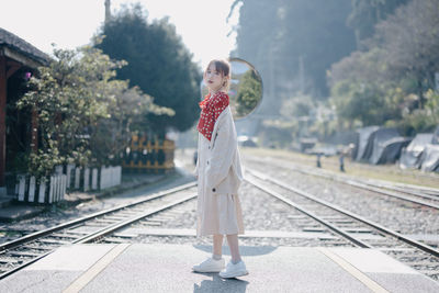 Full length of young woman standing on road