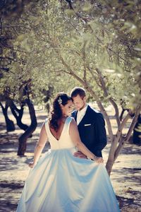 Newlywed couple standing amidst trees