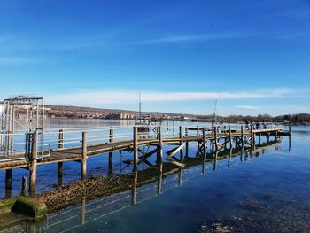 Pier over sea against blue sky