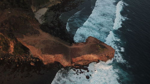 Aerial view of waves crashing on rocky coastline