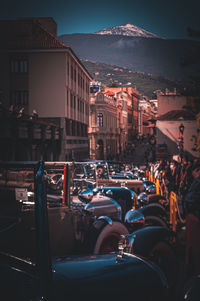 The exhibition of vintage cars is lined up looking towards the snowy teide 