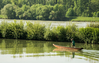 Man in boat on lake against trees