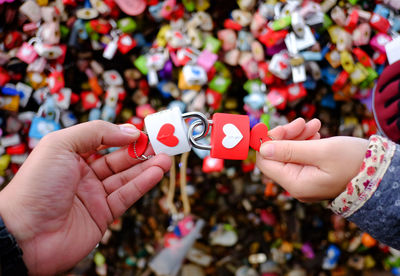 Cropped hands of couple holding love locks