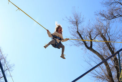 Low angle view of girl against clear sky