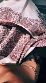 Midsection of woman relaxing on bed