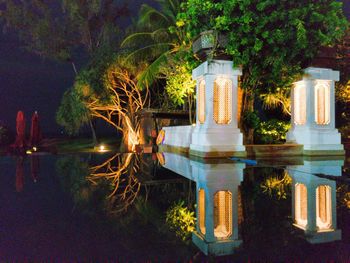 Swimming pool by lake in city at night