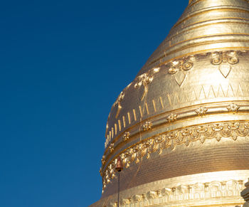 Low angle view of ornate building against clear blue sky