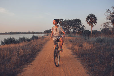 Man smiling while riding his bicycle outdoor in summer