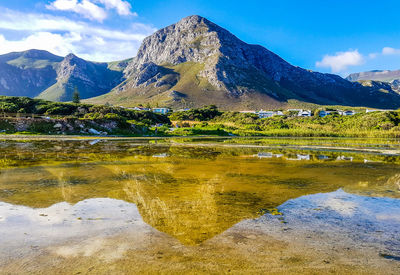 Scenic view of lake by mountain against sky