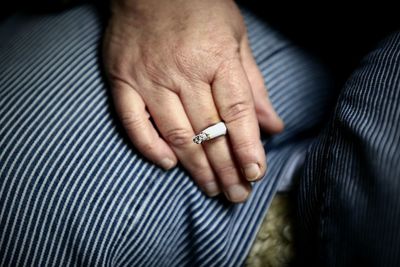 Midsection of man holding cigarette