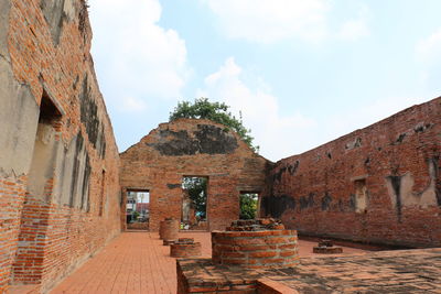 View of old buildings against cloudy sky