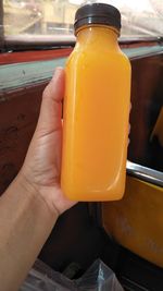 Close-up of person holding glass of juice