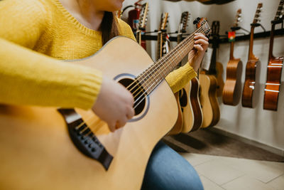 Midsection of man playing guitar