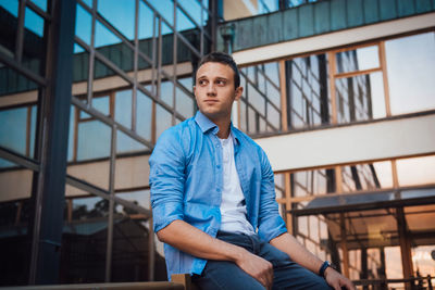 Portrait of young man standing against wall