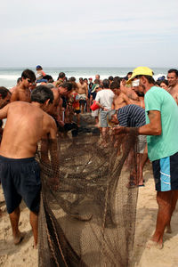 People at beach against sky