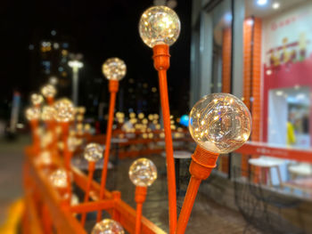 Close-up of illuminated lighting equipment hanging at shop