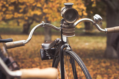 A penny-farthing bicycle with an old headlight in a park