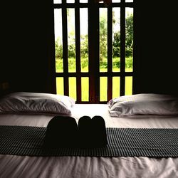 Low section of person relaxing on bed at home