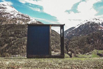 Built structure on land by mountain against sky