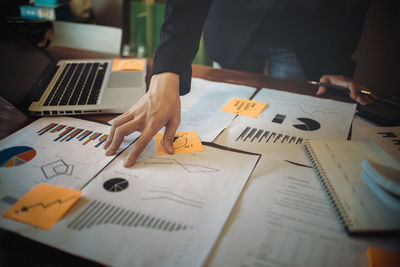 Midsection of businesswoman working over graph in office